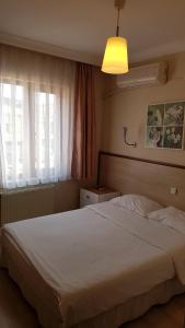 a bedroom with a white bed and a window at Hotel Crowded House in Eceabat