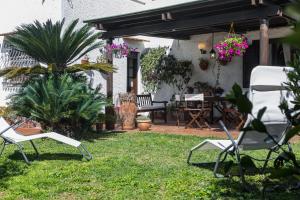 a yard with two chairs and a table and a table at Villa Gabriella - Mondello in Mondello