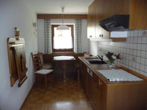 a small kitchen with a table and a counter top at Garni Bonaria in Corvara in Badia