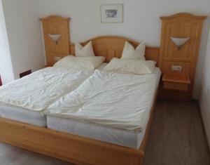 sypialnia z dużym łóżkiem z białą pościelą i poduszkami w obiekcie Landhaus Relly w mieście Seefeld in Tirol