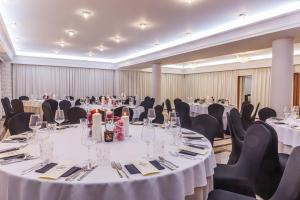 a banquet room with tables and chairs with white tablecloths at Villa Palladium in Gdańsk