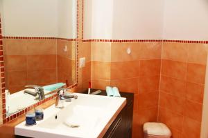 a bathroom with a sink and a mirror at Sardinia Re - Attico Baja Ostina in Castelsardo +18 photos