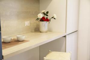 a shelf with two cups and a vase with flowers at SARDINIA RE - Attico Baja Ostina in Castelsardo +65 photos