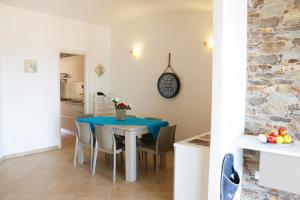 a dining room with a blue table and chairs at Sardinia Re - Attico Baja Ostina in Castelsardo