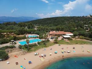 una vista aerea di una spiaggia con persone e ombrelloni di Village Naturiste La Chiappa a Porto Vecchio