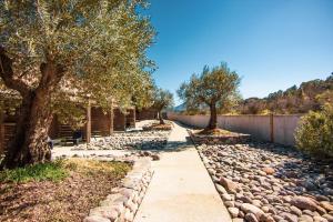 a walkway with trees and rocks next to a fence at Hôtel Ascosa Aventure in Ponte-Leccia