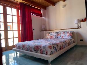 a bedroom with a bed in a room with windows at Casa Luna in Lipari