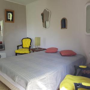 ReillanneにあるLes Marronniersのベッドルーム1室(ベッド1台、黄色い椅子2脚付)