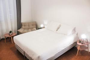 um quarto com uma cama branca e uma cadeira em Best quality price ! - Central - 350m Palais and Croisette em Cannes