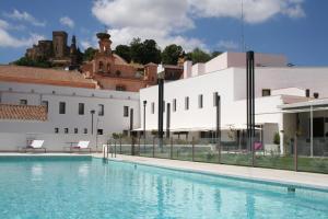 a swimming pool in front of a white building at Hotel Convento Aracena & SPA in Aracena