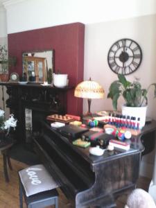 a room with a piano with a lamp on it at The Breverton in Lytham St Annes