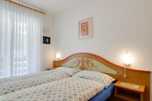 1 dormitorio con 1 cama con 2 almohadas en Appartamenti Cesa Maria Mountain Hospitality, en Canazei