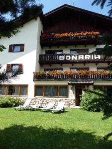 a building with lounge chairs in front of it at Garni Bonaria in Corvara in Badia