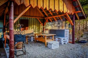 a wooden pavilion with a picnic table and a bench at Domek Koniec Świata in Dzianisz