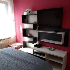 a bedroom with a bed and a flat screen tv at Apartments Kolorček in Izola