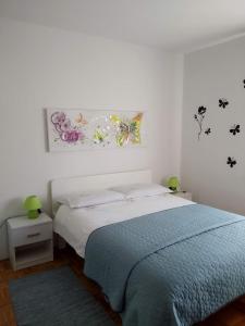 a bedroom with a bed and a painting on the wall at Apartments Kolorček in Izola