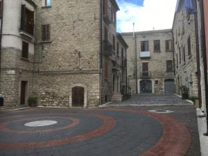 an empty street in an old building with a clock at Pretoria House in Potenza