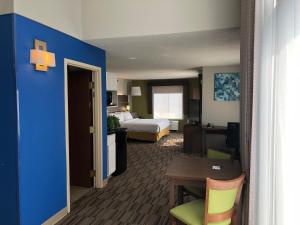 a hotel room with a bedroom with a bed and a table at Holiday Inn Express and Suites - Quakertown, an IHG Hotel in Quakertown