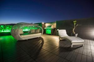a patio with a couch and two chairs on a deck at Zambelis Athens Penthouse Spa in Athens