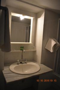 y baño con lavabo, espejo y espejo. en Vecchio Hotel, en Rethymno
