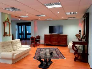 a living room with white furniture and a flat screen tv at Domus Salentina in Leverano