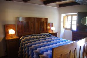 een slaapkamer met een bed met een blauw dekbed bij Vinco in Castel del Rio