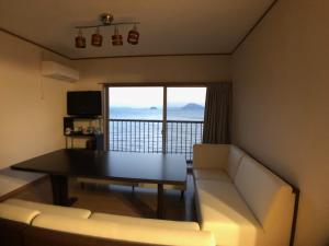 een woonkamer met een bank en een tafel met uitzicht bij villa chillon in Shodoshima