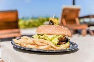 a sandwich on a plate with french fries at Zomay Beachfront Holbox in Holbox Island