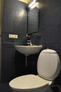 a bathroom with a white toilet and a sink at Thyme the Transit in Bangalore