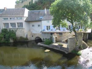 uma ponte sobre um rio em frente a um edifício em MOULIN DE L'ABBESSE em Thouars