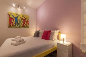Un dormitorio con una cama blanca con almohadas rojas. en Colosseum Lovely Apartment, en Roma 24 fotos más