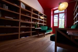 a living room with red walls and wooden shelves at CHASSE-SPLEEN Les Chambres in Moulis-en-Médoc