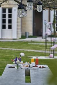 a picnic table with food and flowers on it at CHASSE-SPLEEN Les Chambres in Moulis-en-Médoc