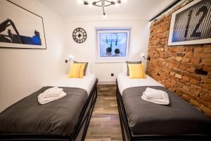 two beds in a room with a brick wall at UNDERGROUND GDYNIA in Gdynia