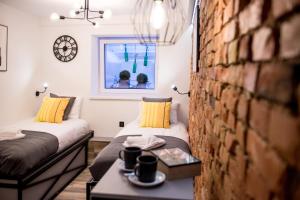 a bedroom with two beds and a brick wall at UNDERGROUND GDYNIA in Gdynia