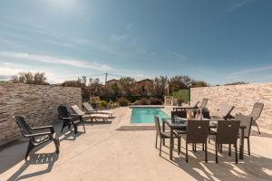 a patio with chairs and a table and a pool at Le Domaine De Marie in Palasca