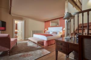 a bedroom with a bed and a table and a chair at Whatley Manor in Malmesbury