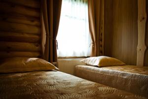 2 camas en una habitación con ventana en Atostogų Parkas Hotel en Palanga