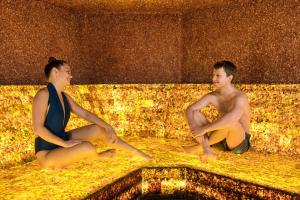 a man and a woman sitting in a bath tub at Atostogų Parkas Hotel in Palanga