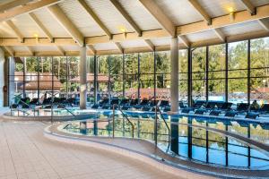 uma grande piscina com cadeiras num edifício em Atostogų Parkas Hotel em Palanga