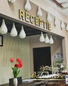 una señal de recepción en una pared con flores rojas y luces en Hotel Belvedere, en Botoşani