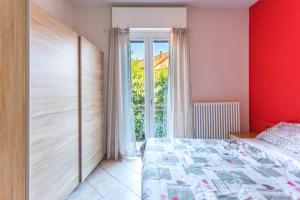 een slaapkamer met een rode muur, een bed en een raam bij il Cortiletto in Stresa