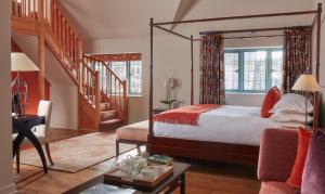 a bedroom with a canopy bed and a staircase at Whatley Manor in Malmesbury