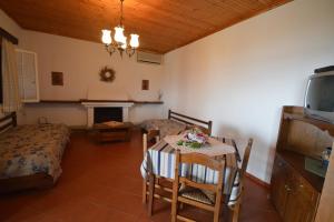 a room with a table and a bed and a dining room at Triantafyllia's House in Agios Ioannis Pelio