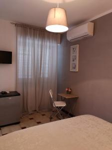 a bedroom with a bed and a desk and a chair at Villa Rosa in Agropoli