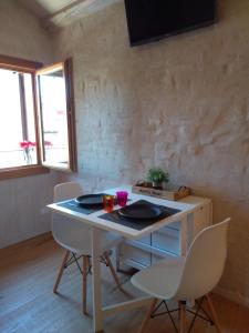 Zimmer mit einem Tisch, 2 Stühlen und einem TV in der Unterkunft Biennale House in Venedig
