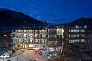 a building with a parking lot in front of it at Sarthak Resorts-Reside in Nature with Best View, 9 kms from Mall Road Manali in Manāli