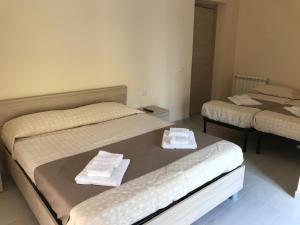 カルタニッセッタにあるB&B Trieste Caltanissettaのタオル付きのドミトリールームのベッド2台