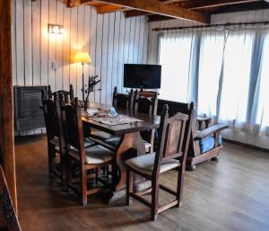 uma sala de jantar com uma mesa de madeira e cadeiras em Cabañas Villa Pañil em San Carlos de Bariloche