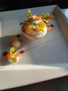 a dessert on a white plate with fruit on it at Hotel Restaurant de la Marne in Paimpol